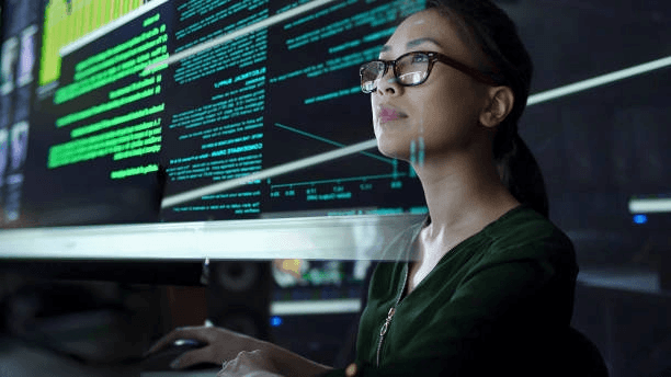 Analyste de cybersécurité supervisant plusieurs écrans dans un centre opérationnel de sécurité