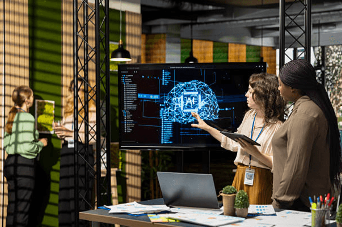 Deux collaboratrices présentant un cerveau numérique affiché sur un grand écran